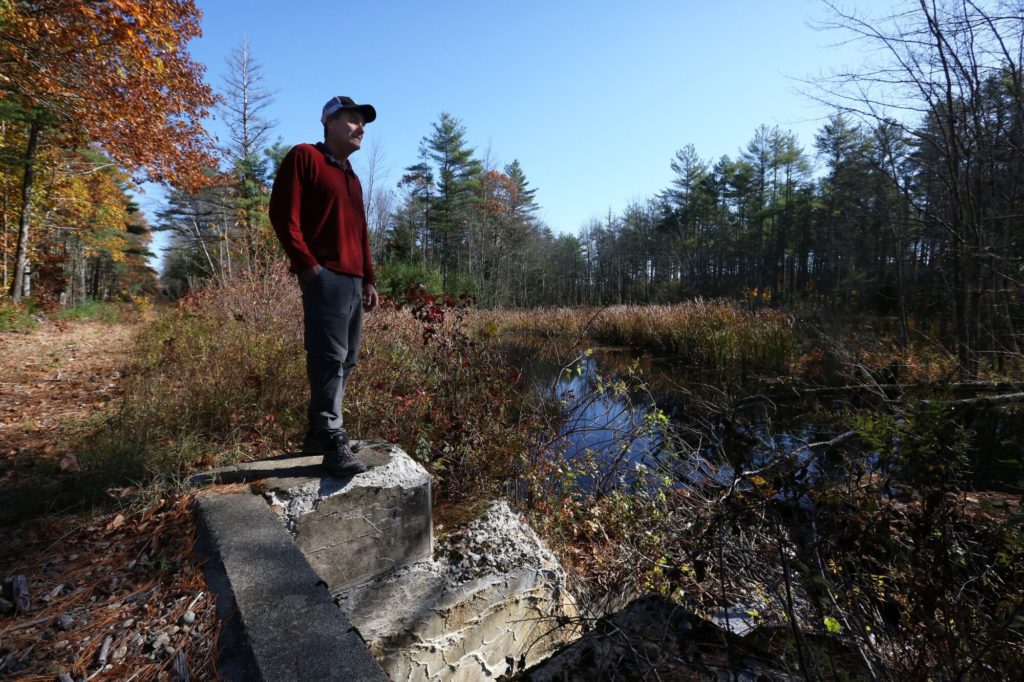 Jon Kachmar, executive director of the Eastern Trail Alliance, stands on a culvert at West Brook that runs under the next phase of the off-road trail expansion.